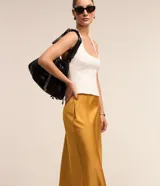 Pollera midi evasé de color beige claro, confeccionada en tela satinada de poliéster.