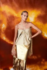 Pollera midi dorada con flecos en el ruedo.