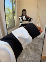 Buzo oversize de tela deportiva con felpa, a rayas horizontales negras y blancas, con cuello redondo y logo pequeño bordado en el pecho.