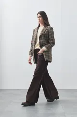 Pantalón de pana de corte wide leg, color marrón oscuro, con calce relajado y detalle de bordado en el borde de los bolsillos delanteros.