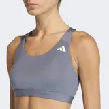 Top deportivo Adidas de soporte medio, color gris, con diseño racer-back y logo de la marca estampado en el frente. Confeccionado en tejido técnico transpirable con tecnología Climacool y almohadillas removibles.