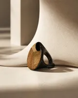 Anillo de diseño escultórico con estructura de cuero negro y aplique frontal de ópalo andino con vetas naturales.