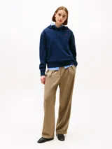 Buzo azul marino con capucha y cordón ajustable, confeccionado en algodón. Presenta logo de Tommy Hilfiger bordado en rojo en el pecho.