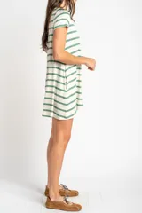 Vestido corto de corte recto y holgado con diseño de rayas horizontales verdes y fondo crudo, escote redondo y mangas corta.