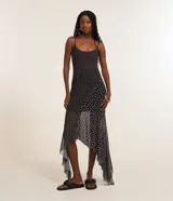 Vestido midi negro de tule con estampado de lunares blancos, breteles finos y corte irregular con puntas.