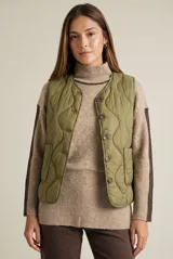 Chaleco capitoneado color verde oliva, con cierre frontal de botones, cuello redondo y diseño acolchado con costuras onduladas.