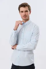 Camisa lisa de manga larga de algodón en color gris claro, de corte slim fit con cuello camisero y cierre frontal de botones.