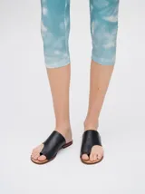 Sandalias chatas de cuero color crudo, con diseño geométrico y minimalista.