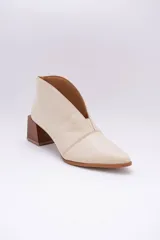 Botines de cuero color beige con diseño de tajo frontal, punta fina y taco cuadrado de madera.