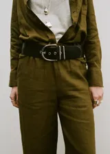 Pantalón largo de lino color verde militar, de corte recto y tiro medio con cintura elástica ajustable y dos bolsillos laterales.