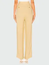 Pantalón de vestir color amarillo, de corte palazzo, con bolsillos laterales y trabillas para cinturón.