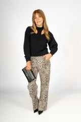 Pantalón largo de vestir con estampado animal print en tonos beige y negro. Corte recto, tiro alto y bolsillos laterales.