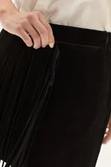 Falda corta de cuero color marrón, con diseño de flecos largos desmontables que cubren toda la prenda. Presenta un estilo western con cierre en la cintura.