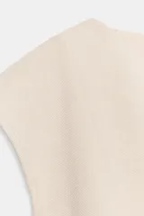 Top blanco de piqué con cuello redondo y mangas cortas, de corte entallado en la cintura y bajo redondeado con acabado en peplum.