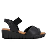 Sandalias de cuero negro con plataforma baja y elástico en el tobillo.