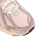 Championes New Balance modelo 1906, con diseño técnico en tonos rosa y detalles metalizados plateados. Presenta una estructura de malla transpirable, refuerzos sintéticos y entresuela con tecnología de amortiguación en color crema.