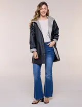 Pilot engomado impermeable color azul, de corte recto estilo trench con acabado resistente al agua. Cuenta con capucha integrada, cierre frontal con broches a presión, bolsillos laterales con ojal y forro interior de tela estampada a cuadros visible en la solapa y los puños.