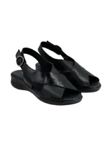Sandalia de cuero negro con diseño de tiras cruzadas en el empeine, una de ellas con textura grabada. Cuenta con cierre de hebilla lateral y suela plana ergonómica.