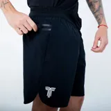 Short deportivo negro con cintura elástica, bolsillo lateral con cierre termosellado y logo estampado en el frente. Presenta aberturas laterales en el ruedo y detalles microperforados.