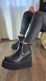 Botas cortas de cuero color suelo y negro con detalles en animal print de leopardo, con plataforma y taco cuña tricolor en negro, blanco y suela. Incorpora elásticos laterales estilo chelsea.