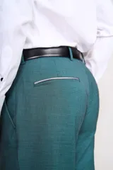 Ambo de ceremonia color verde petróleo, compuesto por saco de dos botones, pantalón de corte recto y chaleco gris con estampado jacquard. Incluye pañuelo de bolsillo y corbatón a juego.