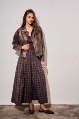 Pantalón de corte wide leg con diseño de cuadros, tiro medio y pinzas frontales que aportan volumen y movimiento a la prenda.