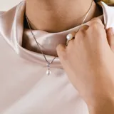 Conjunto compuesto por collar y anillo en plata 925, ambos con perla de río natural y engarce de circonia. El collar presenta una cadena fina con dije de perla colgante y el anillo destaca por su diseño minimalista con perla central.