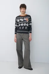 Buzo de tejido de punto con cuello redondo, manga larga y diseño estampado con motivos florales y abstractos en tonos claros sobre base oscura.