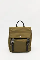 Mochila urbana de nylon color beige, con solapa superior, bolsillo frontal con cierre y correas decorativas con hebillas metálicas. Incluye manija superior y correas ajustables.