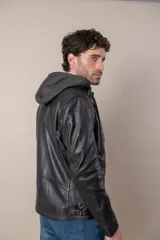 Campera de cuero negro con capucha gris desmontable, cierre frontal, bolsillos con cierre y detalles de hebillas en el cuello y la cintura.