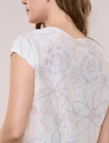 Buzo tejido de punto liviano y silueta holgada, con cuello bote cerrado, mangas cortas estilo japonesa, espalda de caída recta y ruedo curvo a la cadera. Presenta diseño estampado floral en tonos pasteles.