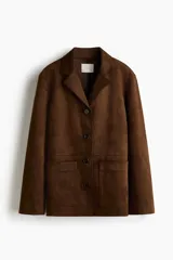 Campera marrón de tejido suave con acabado cepillado, solapas de muesca, cierre frontal de botones oscuros y bolsillos frontales tipo parche. Cuenta con forrería interior.