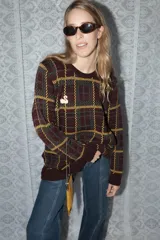 Buzo tejido de punto con diseño de cuadrillé en tonos bordó, verde y amarillo. Presenta cuello redondo, mangas largas y un detalle de cisne bordado en el pecho.