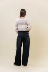 Jean wide leg de tiro alto con calce relajado y pierna amplia. Confeccionado en denim con leve desgaste, cuenta con cintura definida con presillas, bolsillos clásicos y cierre frontal con botón metálico.