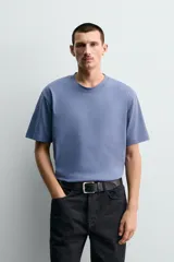 Camiseta de corte regular confeccionada en tejido de algodón compacto, con cuello redondo y manga corta.