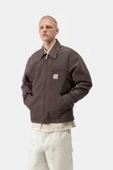 Chaqueta Detroit de Carhartt WIP color marrón, de corte recto con cierre frontal de cremallera, cuello clásico de pana y bolsillos laterales. Cuenta con un bolsillo con cierre en el pecho decorado con la etiqueta del logo de la marca.