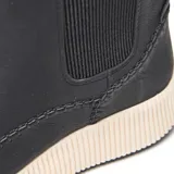 Bota corta tipo Chelsea de símil cuero liso color negro, con paneles laterales elastizados y tira trasera para facilitar el calce. Presenta costuras visibles con detalle artesanal, punta redondeada y plataforma baja integrada con suela de goma antideslizante.