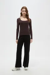 Top de manga larga color blanco, con cuello redondo amplio y ajuste al cuerpo.