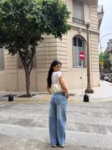 Pantalón de jean estilo wide leg y tiro bajo, en tono azul claro con efecto deslavado y diseño de perneras amplias.