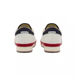Championes Lacoste modelo Aura, de diseño retro con base de cuero color blanco, detalles en azul marino en el talón y lengüeta, franja lateral roja y suela de goma color caramelo.