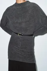 Vestido corto de tejido suave color gris oscuro, con cuello redondo y manga larga. Incluye un cinturón fino de efecto piel con hebilla metálica dorada.