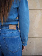Pantalón jean de tiro medio, corte recto y amplio con caída estilo wide leg, en tono azul clásico.