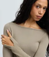 Suéter de punto ajustado en color marrón oscuro, con escote canoa y mangas largas que presentan una pequeña abertura en los puños. Diseño minimalista y versátil con acabado liso.