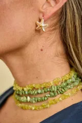 Aros caravanas con diseño de estrella de mar en color blanco con detalles dorados.