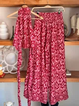 Conjunto de dos piezas color fucsia con estampado oriental en tonos rosa y blanco, compuesto por un top halter con lazo en la cintura y un pantalón palazzo de cintura alta con elástico.