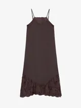 Vestido largo celeste de lino, de silueta recta y finos breteles regulables, con detalles de encaje aplicado en el escote y en el ruedo asimétrico.