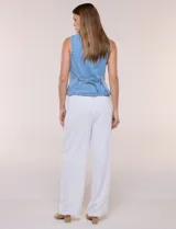 Chaleco de denim azul con silueta entallada, escote redondo cerrado, hilera de botones metálicos frontales y costuras anatómicas.