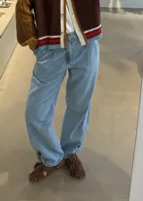 Jean de corte gaucho en color azul, con diseño de pinzas en la cintura, tiro medio y detalle de ajuste con botón en el ruedo.