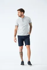 Bermuda tipo chino de gabardina, color azul marino, con cierre de cremallera y botón, bolsillos laterales y traseros, y pasacintos.