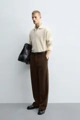 Pantalón de corte wide fit confeccionado en pana de algodón color marrón oscuro. Presenta bolsillos frontales, bolsillos traseros de vivo con botón y cierre frontal con cremallera y botón.